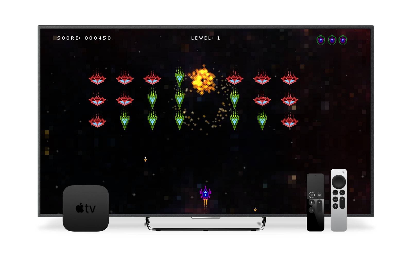 An image of a TV displaying the first level of Invasion of Planet X. In front of the TV is an Apple TV box and two Siri remotes – 1st and 2nd generation.